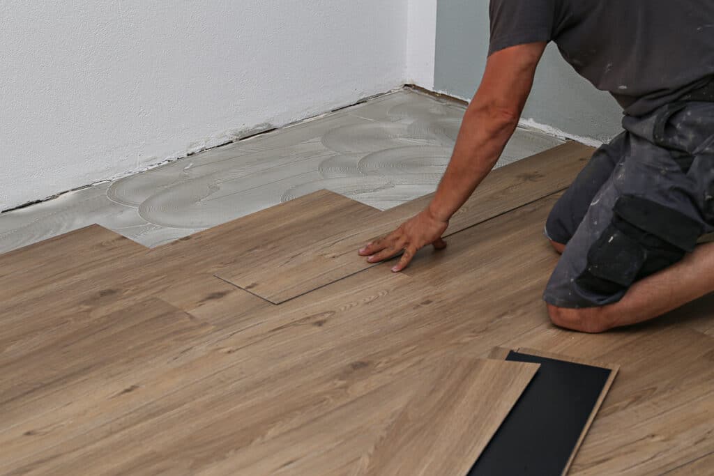 Person installing new vinyl tile floor