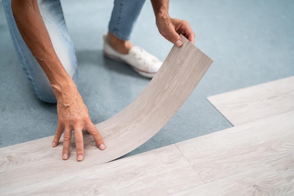 Person installing new vinyl laminate flooring